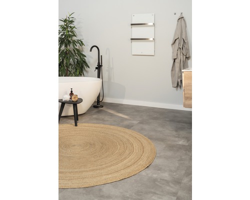 Koupelna s volně stojící vanou, kulatým kobercem a ohřívačem ručníků