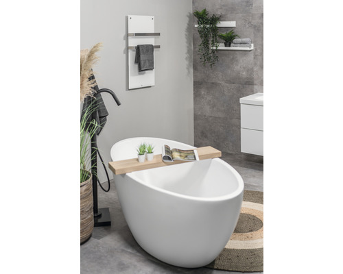 Koupelna s volně stojící vanou, ohřívačem ručníků a dekorativními prvky pro relaxační atmosféru