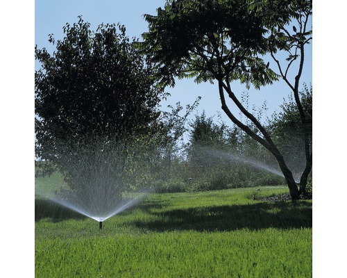 Zavlažování trávníku pomocí zavlažovače trávníku na zahradě