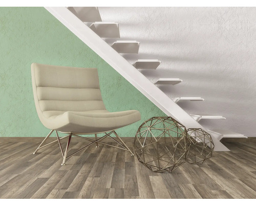 Interiér s křeslem, ozdobnými kovovými koulemi a schodištěm