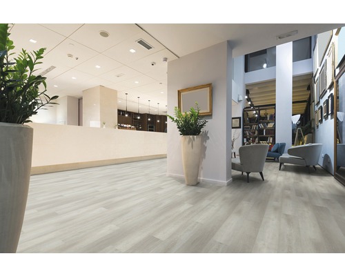 Světlá místnost s podlahou se vzhledem dřeva, recepcí a posezením