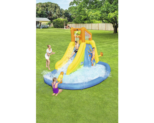 Nafukovací vodní skluzavka s brouzdalištěm a hrajícími se dětmi na zahradě
