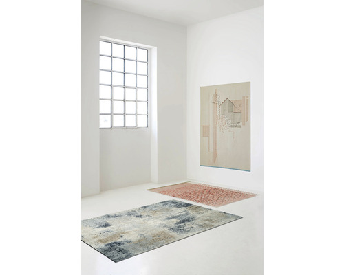 Světlá místnost se dvěma koberci a obrazem na zdi.