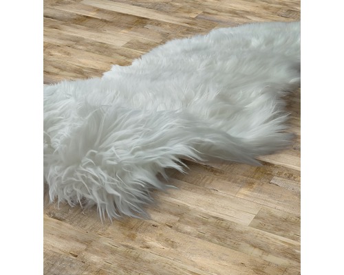 Bílý koberec na dřevěné podlaze