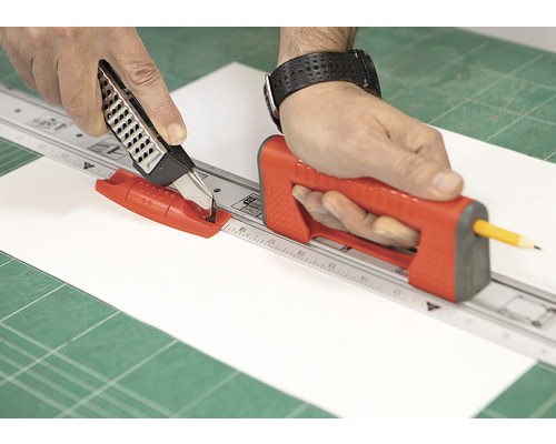 Osoba řeže papír s rolovací řezačkou a řezacím pravítkem