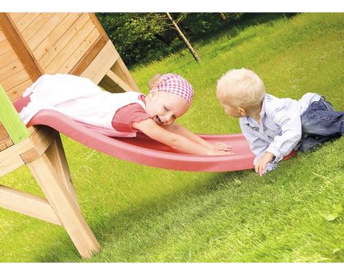 Dvě děti si hrají na dřevěné skluzavce na zahradě.