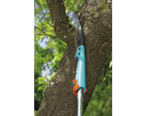 Prořezávací pila řeže větev stromu.