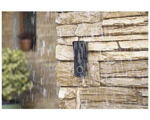 Na kamenné zdi je za deště připevněn zvonek.