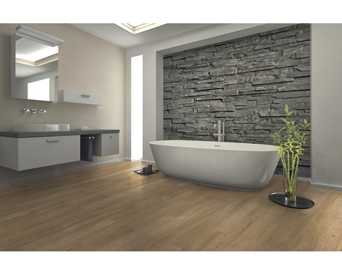 Moderní koupelna s vanou, umyvadlem a kamennou stěnou