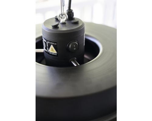 Detailní záběr horní části ohřívače s vypínačem a varováním před horkým povrchem