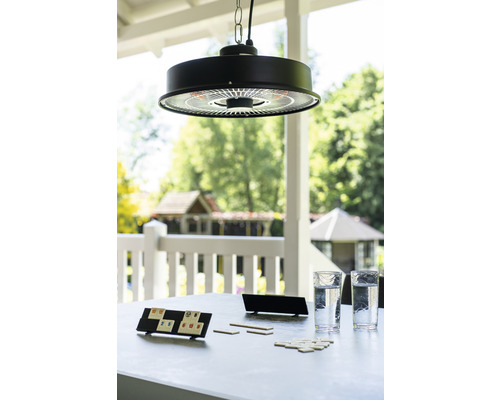 Scéna se závěsným ohřívačem nad stolem se sklenicemi a hrou venku