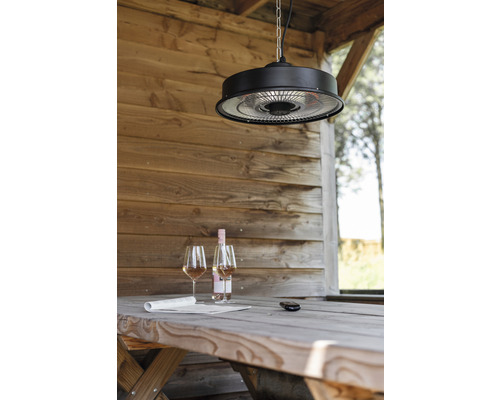 Scéna se stropním ohřívačem nad dřevěným stolem s vínem a novinami v zahradním domku