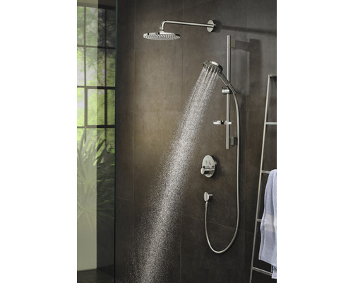 Sprchový systém s horní a ruční sprchou v koupelně s tekoucí vodou.