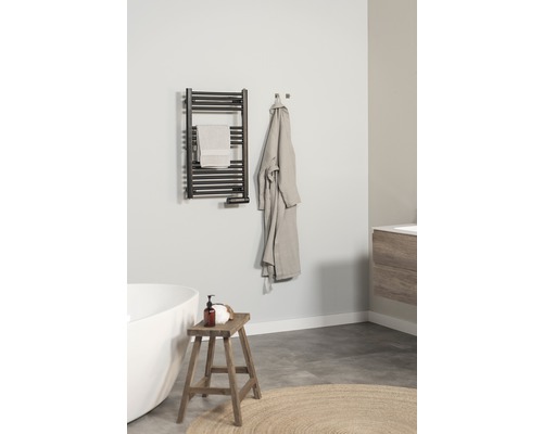 Koupelna s ohřívačem ručníků, ručníkem, županem, stoličkou a vanou