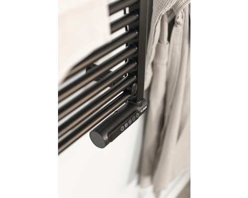 Detailní pohled na radiátor na ručníky s elektronickým ovládáním a ručníkem