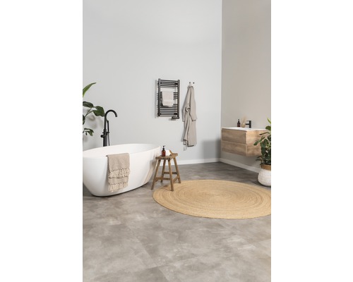 Světlá koupelna s volně stojící vanou, dřevěnou stoličkou a radiátorem