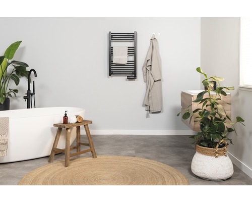 Světlá koupelna s vanou, umyvadlem, topným žebříkem na ručníky a pokojovými rostlinami pro přátelskou atmosféru