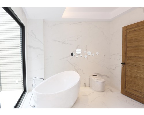 Světlá koupelna s volně stojící vanou, toaletou a dřevěnými dveřmi