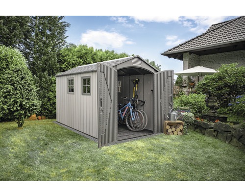 Zahradní kůlna s otevřenými dveřmi, ve které jsou uložena kola a zahradní nářadí