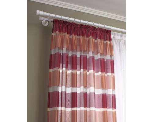 Záclona s proužkovaným vzorem visí na záclonové tyči