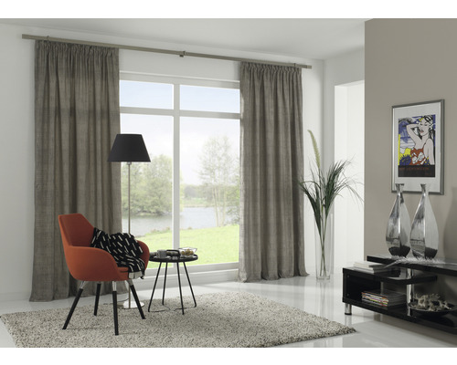 Obývací pokoj se závěsy, křeslem, stojací lampou a dekorací