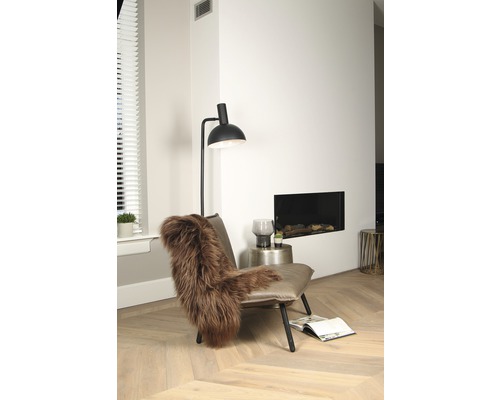 Moderní obývací pokoj s křeslem, lampou a krbem