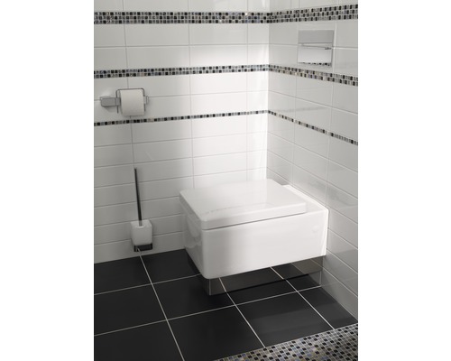 Moderní koupelna s WC zavěšeným na zdi, toaletním kartáčem a držákem papíru