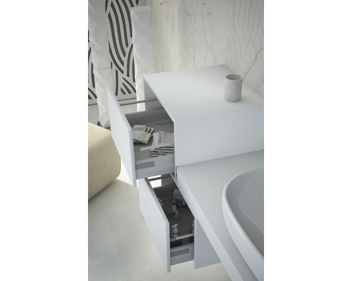 Detailní záběr bílé skříňky pod umyvadlo se dvěma otevřenými zásuvkami, které ukazují ručníky a produkty péče.