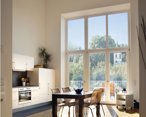 Světlý obývací pokoj s velkým oknem, jídelním stolem a kuchyňským koutem