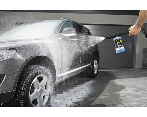 Šedé auto je čištěno vysokotlakým čističem.