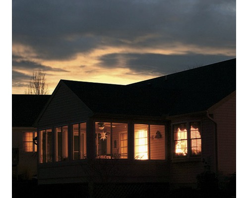 Večerní pohled na dům s osvětlenými okny a terasou