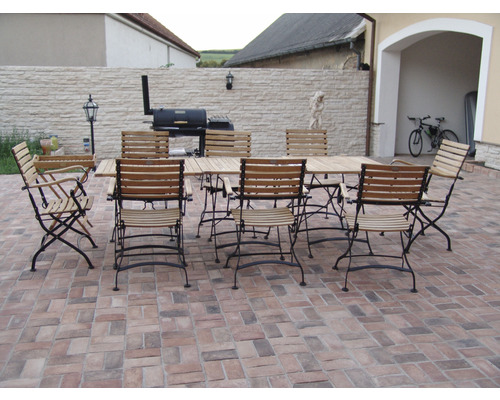 Zahradní scéna s dřevěným jídelním stolem a odpovídajícími židlemi na terase.