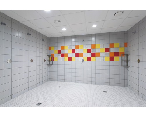 Světlá sprchová místnost s bílými dlaždicemi a barevnými akcenty