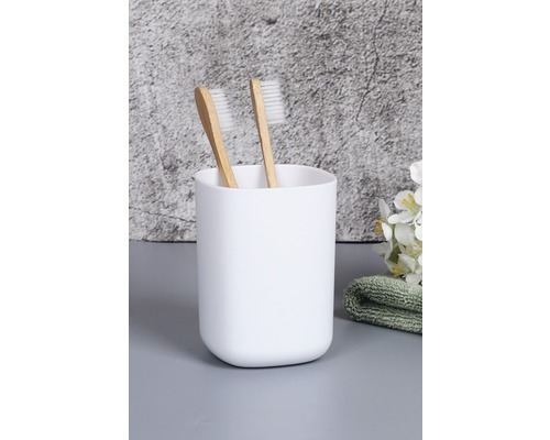 Dva zubní kartáčky v bílém kelímku na zubní kartáčky