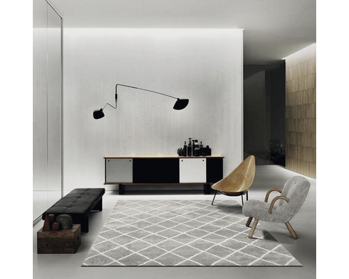 Obývací pokoj s příborníkem, kobercem, křesly a nástěnnou lampou