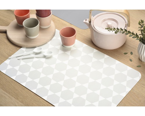 Dekorace stolu s prostíráním, šálky, čajovou konvicí a lžícemi na dřevěném stole