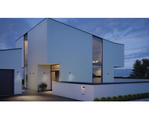 Moderní dům s venkovním osvětlením a velkými okny za soumraku