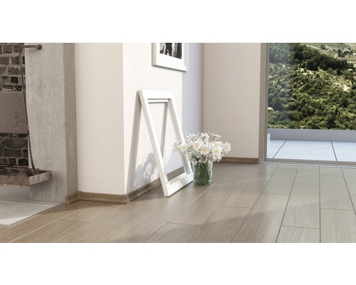 Interiér s dřevěnou podlahou, ozdobnými lištami, rámy na obrazy a květinami