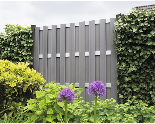 Pohled do zahrady se šedým plotem pro ochranu soukromí a rostlinami