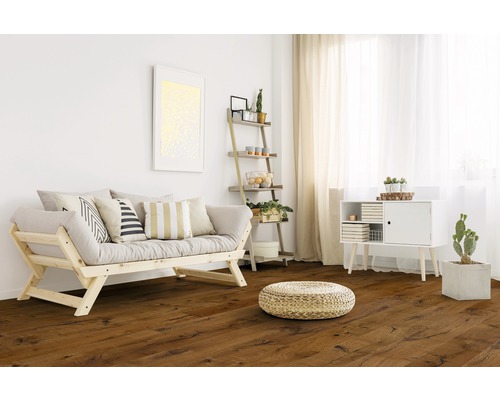 Světlý obývací pokoj s dřevěnou podlahou, pohovkou, regálem a dekoracemi