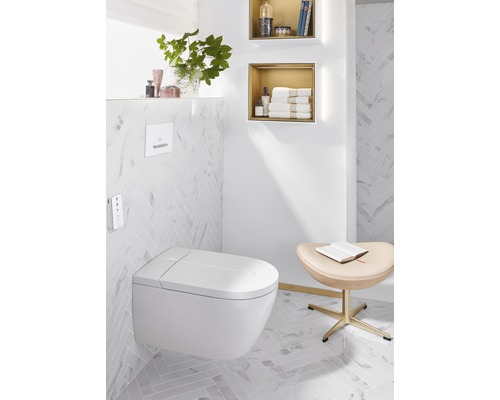 Světlá koupelna se závěsným sprchovým záchodem, policemi a stoličkou.