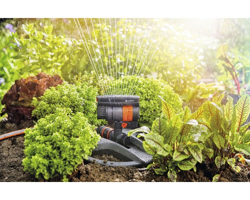 Zavlažovač Gardena v provozu pro zavlažování zahrady mezi rostlinami