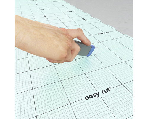 Ruka nožem řeže podložku s mřížkou