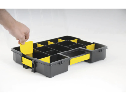 Černý sortimentní box se žlutými vložkami a rukou vkládající vložku