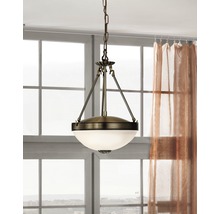 Závěsná lampa se skleněným stínidlem a kovovým závěsem před oknem