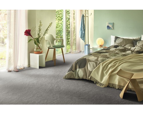 Světlá ložnice se šedým kobercem, postelí a denním světlem