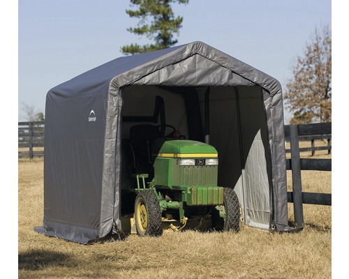 Šedý přístřešek s traktorem na trávu