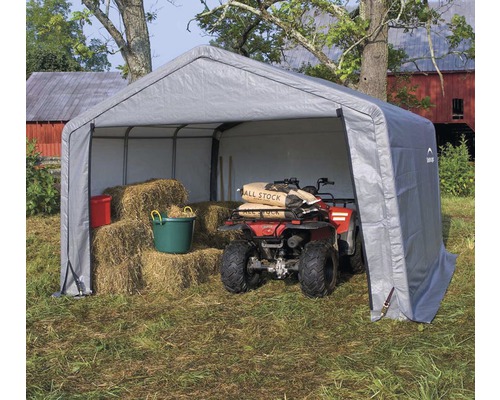 Šedý přístřešek se slámou a čtyřkolkou