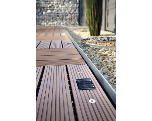 Dřevěná terasová prkna s integrovaným solárním osvětlením v zahradě