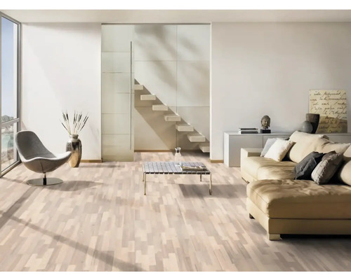 Světlý obývací pokoj s parketovou podlahou, pohovkou, křeslem a schodištěm